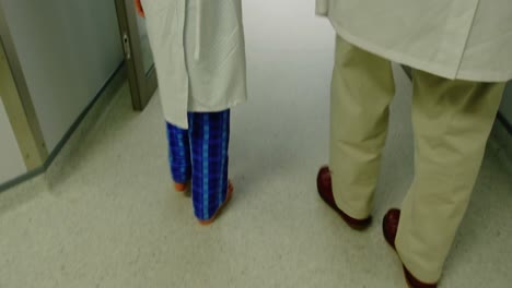 doctor walking with patient in hospital corridor