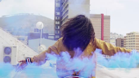 fashionable young woman on urban rooftop using a smoke grenade