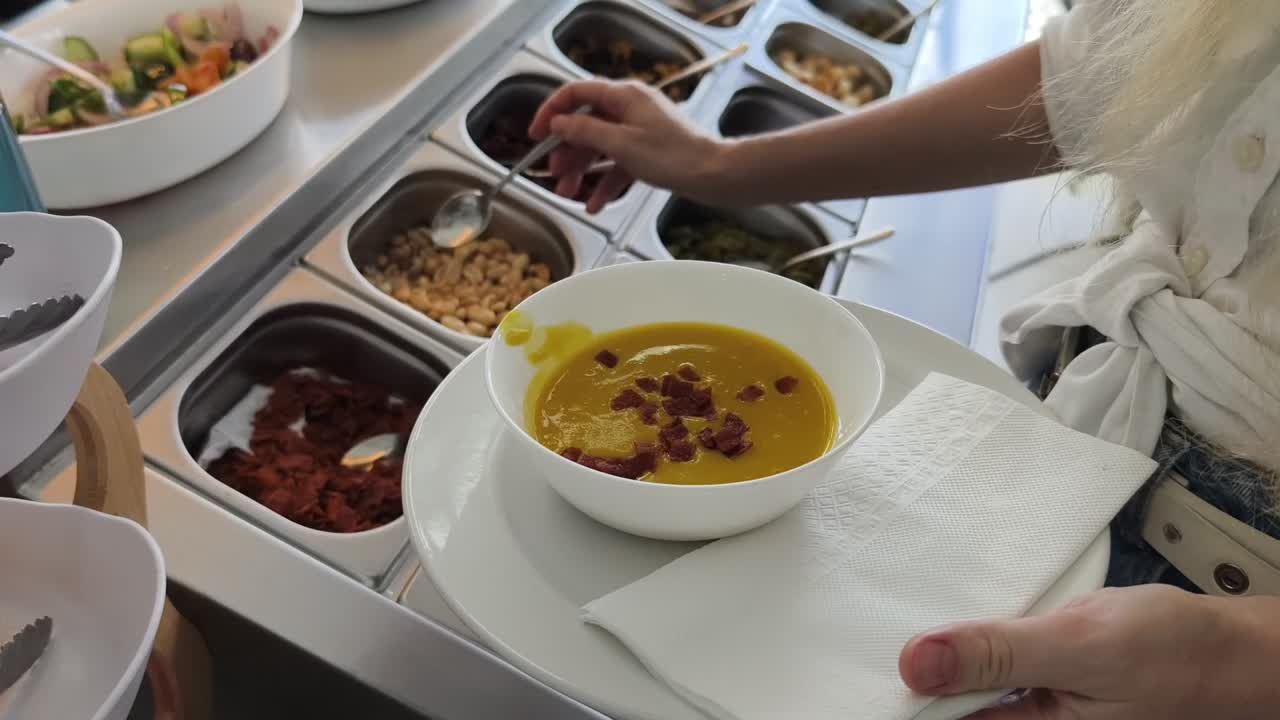 셀프 서비스 레스토랑 에서 수프 를 제공 하는 여자