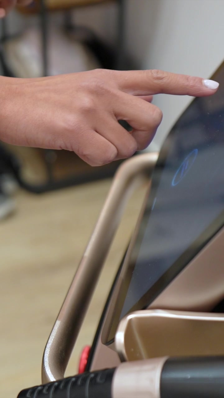 Persona che utilizza l'interfaccia touchscreen su moderne attrezzature fitness