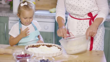 Kleines-Mädchen-Schaut-Gespannt-Beim-Backen-Zu