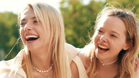 two happy young women laughing outdoors