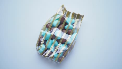 almendras de chocolate azul y marrón en una bolsa de rayas doradas