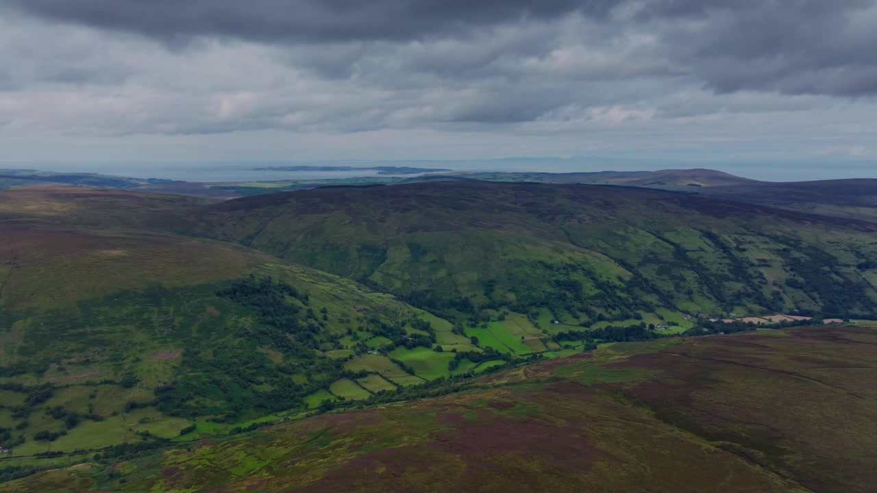 Drone che vola sopra la montagna rivelando una delle Glens of Antrim con ruscelli che scorrono attraverso valli tranquille e colline che si ergono oltre. Luoghi epici dell'Irlanda