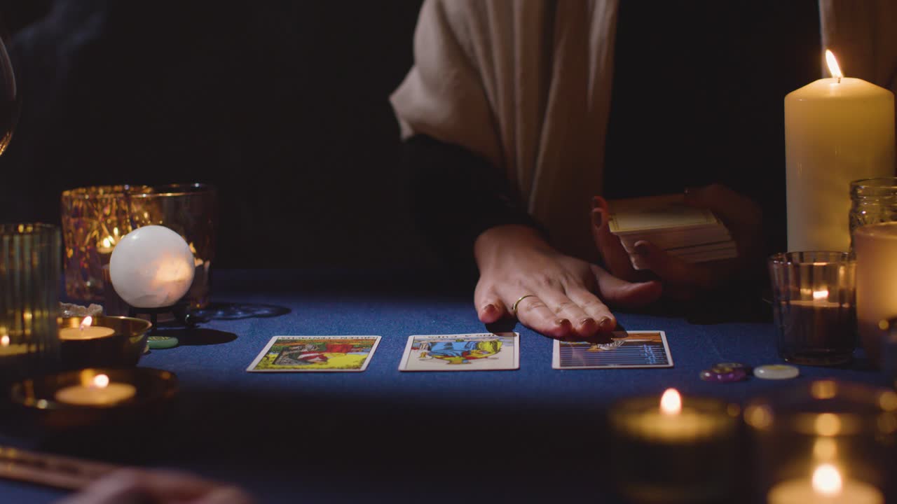 primer plano de una mujer dando una lectura de cartas de tarot a un hombre en la mesa 3 a la luz de las velas
