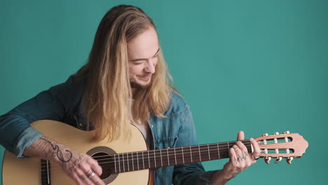 caucasian young man playing guitar on camera.