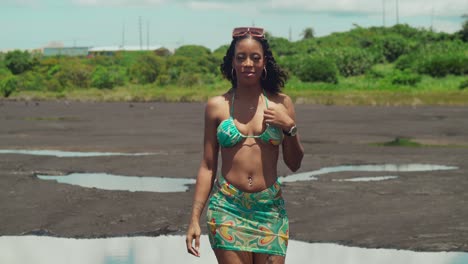 Amidst-the-exotic-landscapes-of-a-Caribbean-pitch-lake,-a-girl-relaxes-in-a-bikini-in-Sulphur-pools