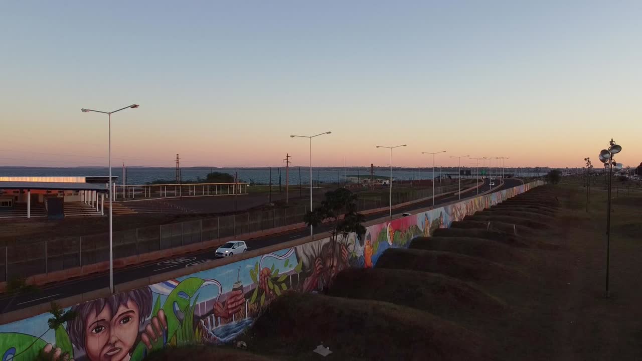 Posto di frontiera tra Argentina e Paraguay, auto che percorrono la strada di confine al tramonto