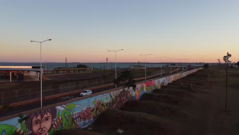 border crossing station of argentina and paraguay, cars driving through border road at sunset