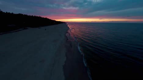 FPV-drone-flying-fast-over-the-waves-of-the-Baltic-Sea-in-Poland-at-sunset,-Pomerania-region