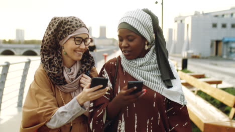 Female-Friends-Using-Smartphones-on-Walk