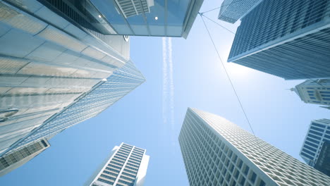 looking-up-view-of-city-skyline-buildings-with-aircraft