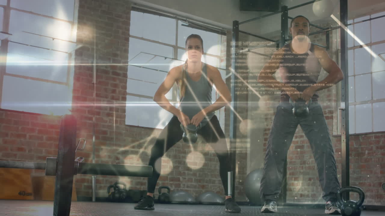 체육관에서 케틀벨을 가지고 운동하는 두 인종의 건강한 커플에 대한 의료 데이터 처리