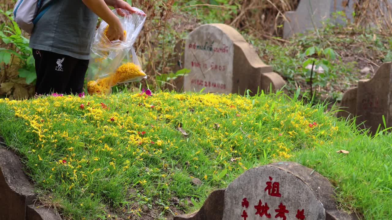 한 사람 이 무덤 에 노란 꽃 을 뿌린다