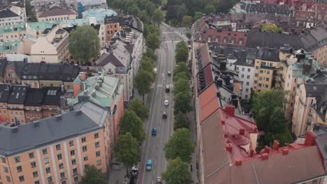 drone footage of apartment buildings, rooftops and road with traffic at karlavägen, stockholm, sweden during mid-day cloudy weather