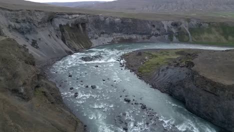 aerial river view surrounded by beautiful mountains and empty roads in the incredible lands of iceland during summer
