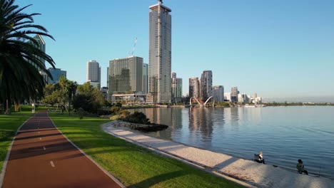 carretera a orillas del río vista del parque sobre el distrito central de negocios en la ciudad de perth con rascacielos al atardecer