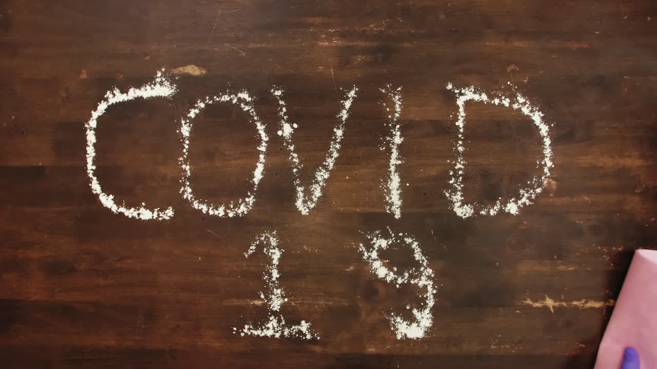 소독제를 뿌리고 분홍색 물티슈로 제거한 covid-19 흰색 문자