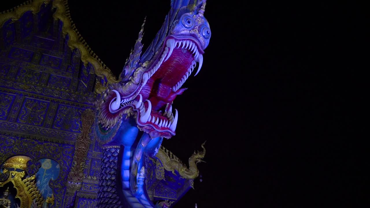 Close up on the head of a Dragon statue by night time at Wat Rong Sear Tean (Blue Temple). Chiang Rai, Thailand.