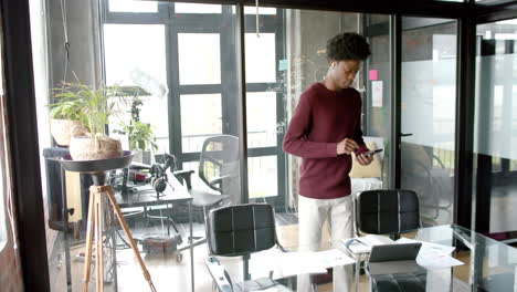 african american casual businessman using smartphone at home office, slow motion, copy space