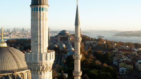 minarets of blue mosque with hagia sophia mosque in the background at sunrise in fatih, istanbul, turkey