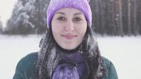 girl in the winter forest after a snow storm runs up to the camera covered with snow