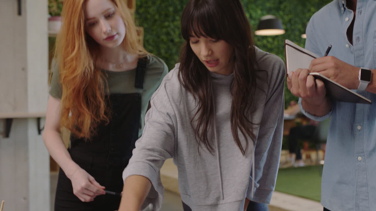 다민족 사업가 들 이 창의적 인 팀 리더 여성 들 이 아이디어 를 공유 하고 협력 하는 것 을 즐기는 동료 들 이 사무실 에서 노트북 을 사용 하여 함께 일 하는 것