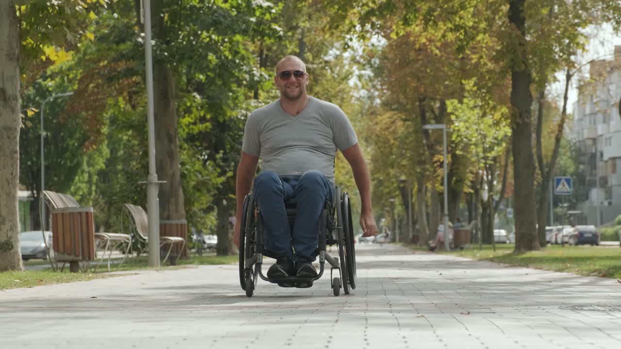 hombre con discapacidad en silla de ruedas camina por el callejón del parque