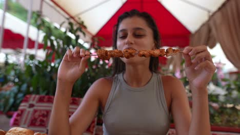 mujer comiendo kebabs al aire libre