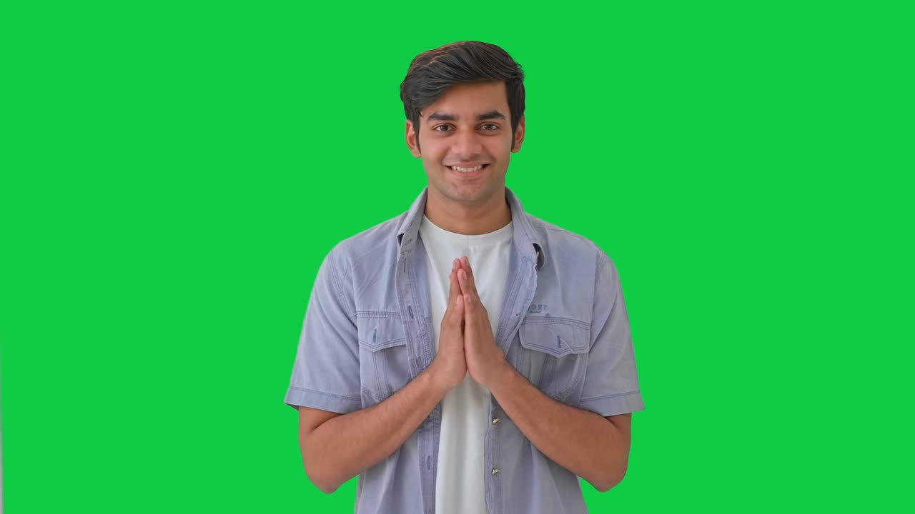 Cute Indian boy doing Namaste and greetings Green screen