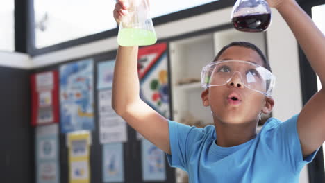 in school, in a classroom, a young asian student examines chemical reactions