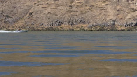 Motorboote-Rasen-In-Zeitlupe-Vorbei,-Während-Sich-Die-Farben-Der-Hügel-Und-Des-Himmels-Im-Seewasser-Spiegeln-–-Lake-Forsyth