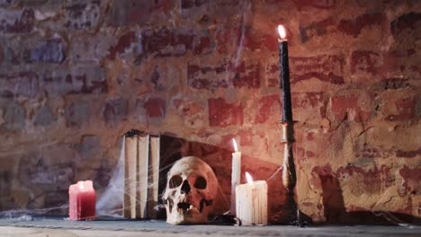 video de una pila de libros con telaraña, cráneo y velas en el fondo de la pared de ladrillo