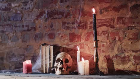 video of stack of books with spider web, skull and candles on brick wall background