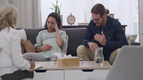 una joven pareja interracial discutiendo durante la terapia
