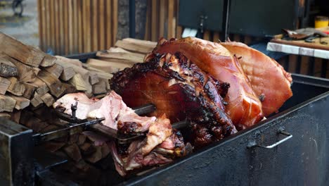 Beechwood smoked ham rotate above grill near firewood, Prague Old Town