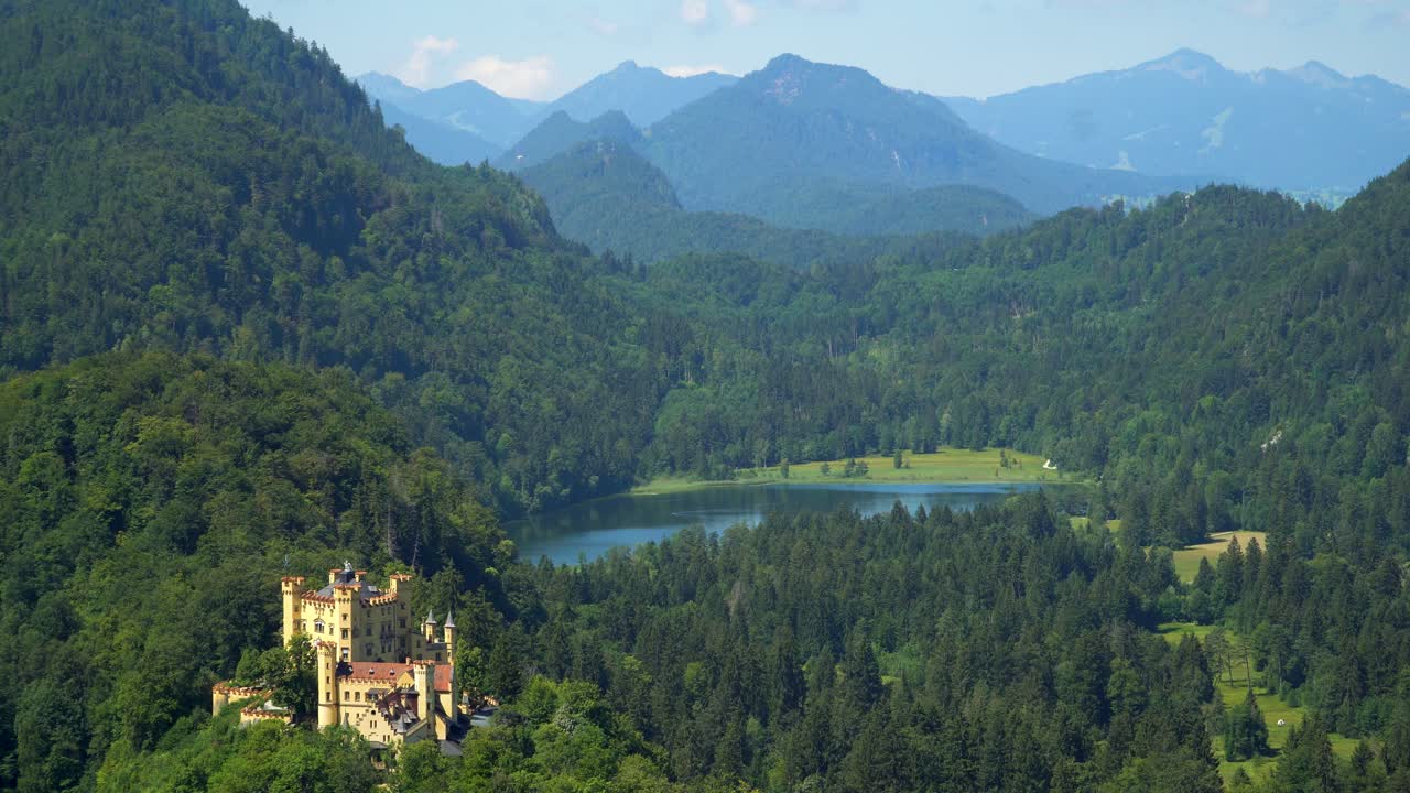 famoso castillo de hohenschwangau en la cima de una colina con vistas a la montaña