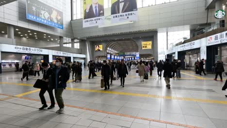 crowd of people walking through a station