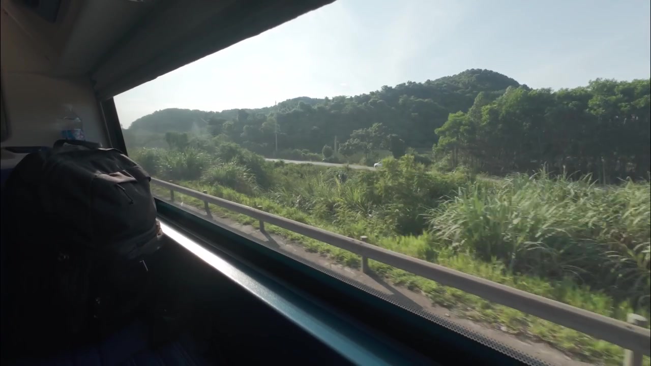 Vista diurna del Vietnam rurale dal finestrino di un autobus letto, che passa campi verdi, villaggi, case e paesaggi di campagna lungo la strada con uno zaino.
