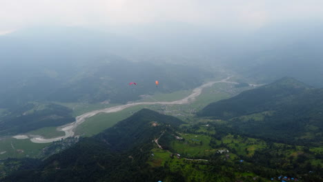 paragliders flying high above the nepal landscape