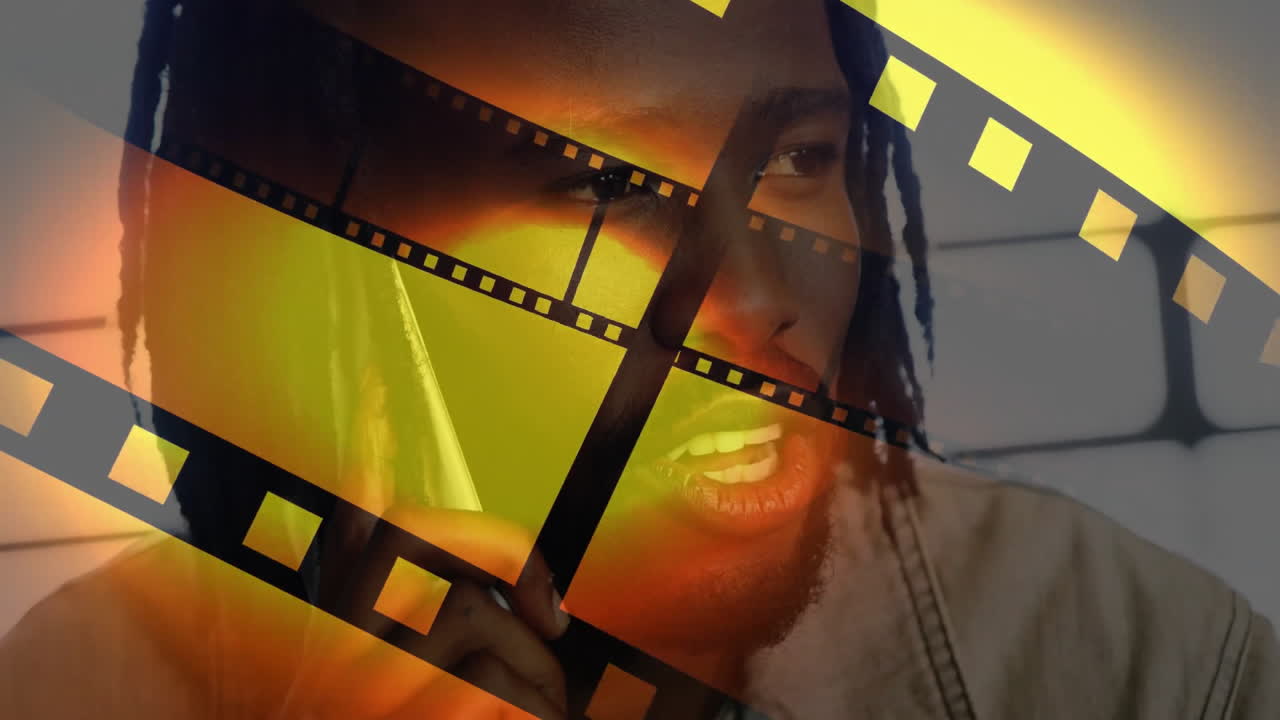 man holding stylus near chin in studio, adding film-strip overlays for technology design