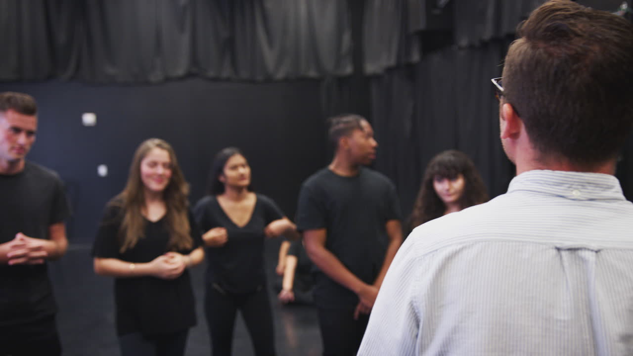 maestro con estudiantes de teatro en la escuela de artes escénicas en la clase de improvisación de estudio