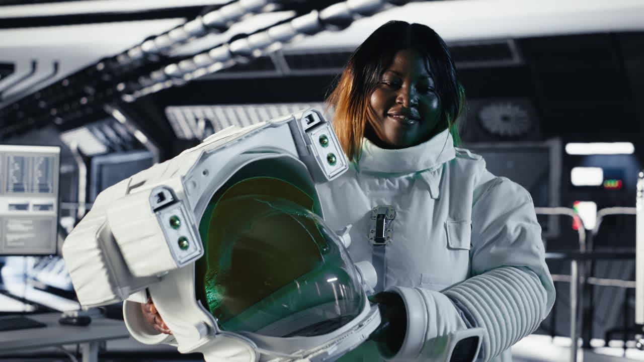 Portrait of happy astronaut holding helmet in space station completing mission
