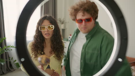 young couple in sunglasses dancing during social media video shoot