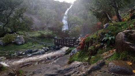 Wasserfall-Felsiger-Fluss-Fließendes-Wasser-Zeitlupenkaskaden-Unter-Holzbrücke-Im-Nationalpark-Weitschuss