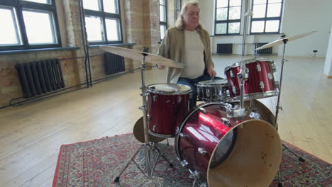 senior male drummer playing music
