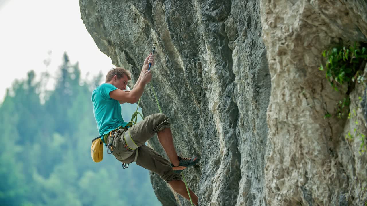 Young powerful man rock climbing up mountain rocky vertical wall, Burjakove peci