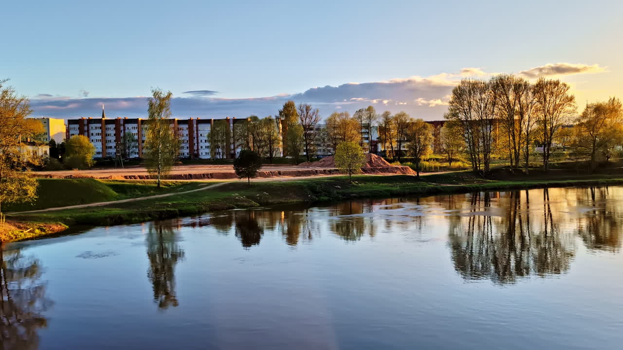 Evening view of Gauja River in Valmiera, Latvia with buildings and construction site