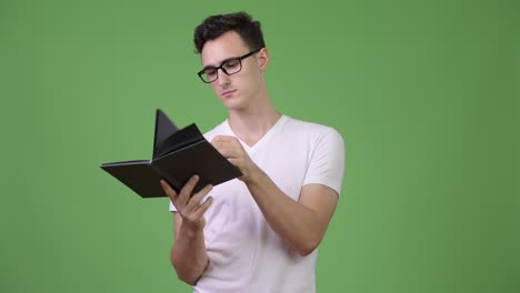 young handsome nerd man reading book