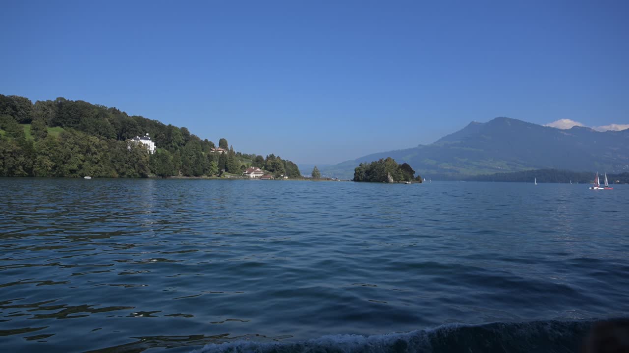 Lake Lucerne, Switzerland - pristine blue waters of the lake and scenic beauty with sailboats, mountains and chalets